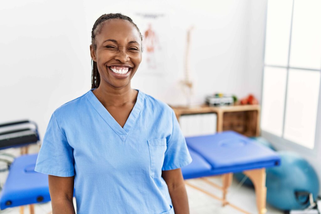 black woman with braids working pain recovery clinic winking looking camera with sexy expression cheerful ha